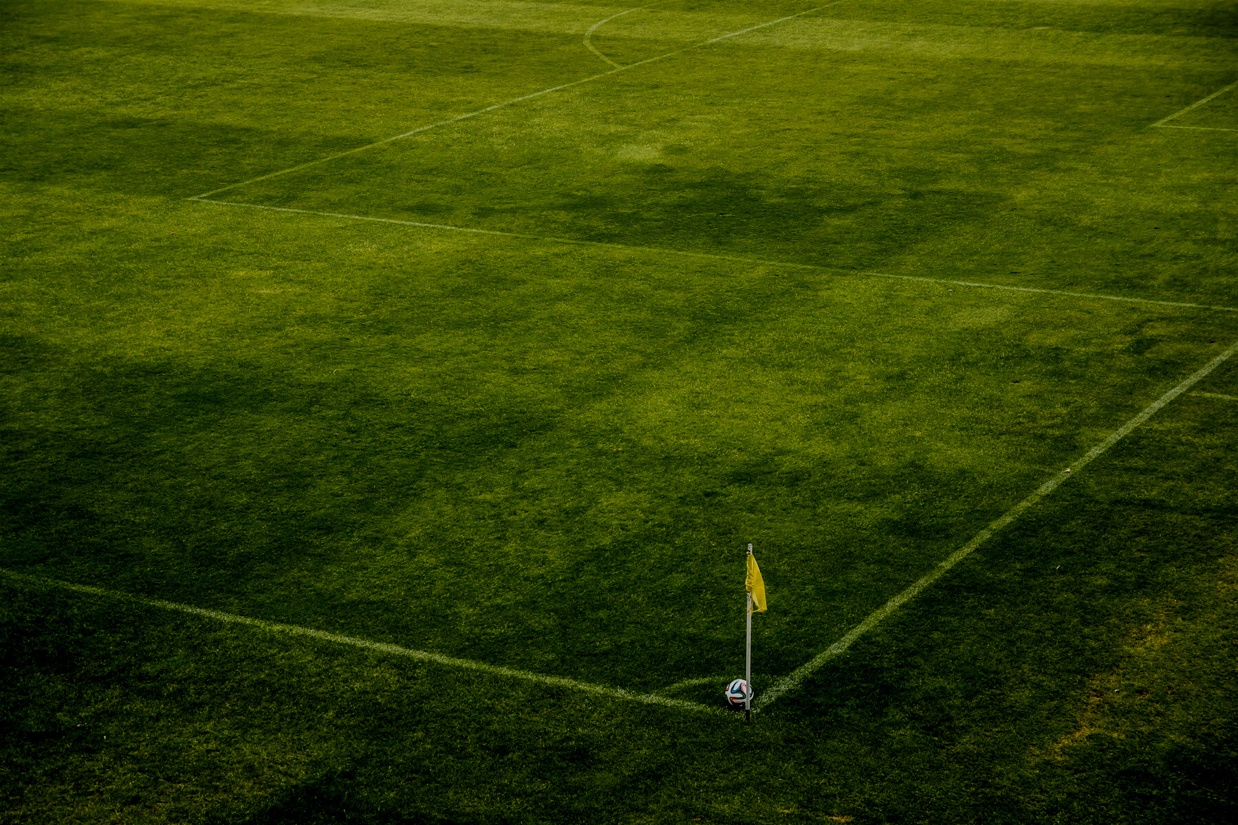 White and Black Soccer Ball on Side of Green Grass Field during Daytime